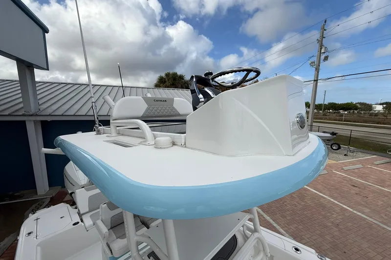 Slide: The Image of 2022 Caymas 28 HB Twin boat helm with blue accents under a cloudy sky. - 19