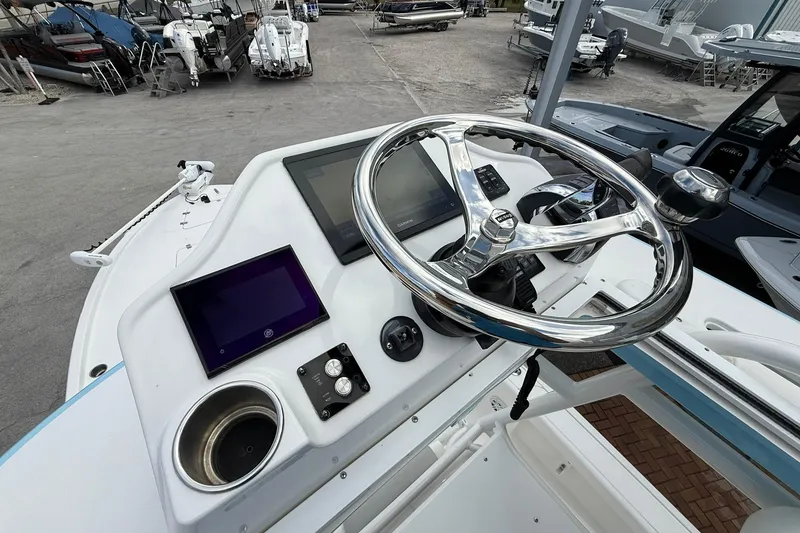 Slide: The Image of 2022 Caymas 28 HB Twin boat dashboard with steering wheel and electronic displays. - 20