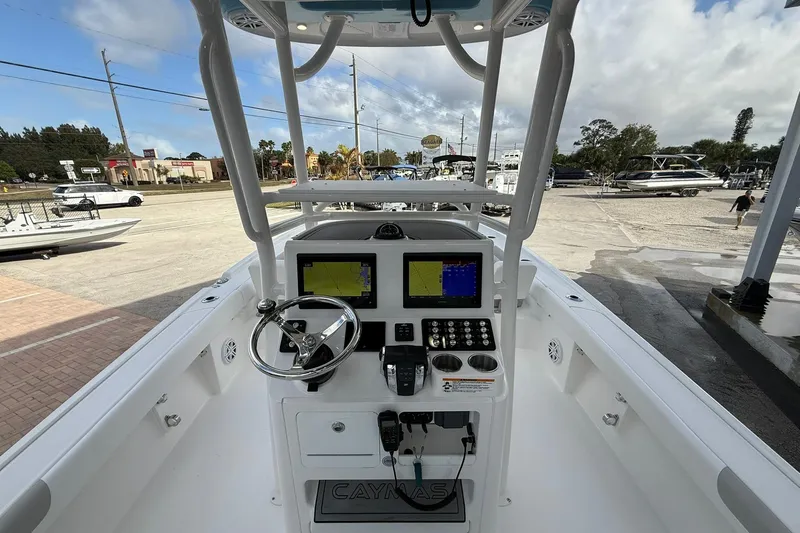 Slide: The Image of 2022 Caymas 28 HB Twin boat dashboard with navigation screens and steering wheel. - 9