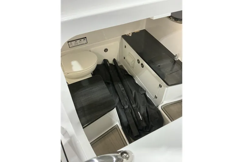 Slide: The Image of 2026 Monterey Elite 25 SD boat interior with toilet and storage area. - 12