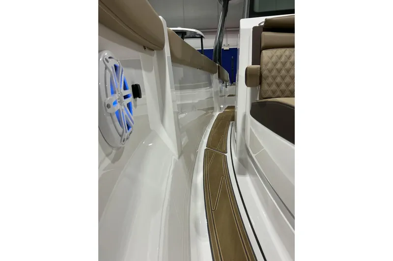 Slide: The Image of 2026 Monterey Elite 25 SD boat interior with cushioned seating and blue-lit speaker. - 14