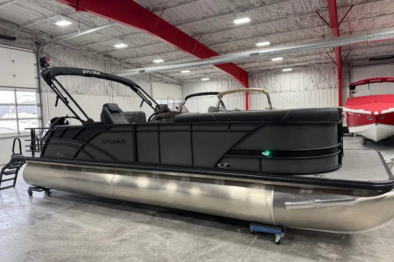 Slide: The Image of 2026 Sylvan X5 pontoon boat in a showroom with red beams and white walls. - 13