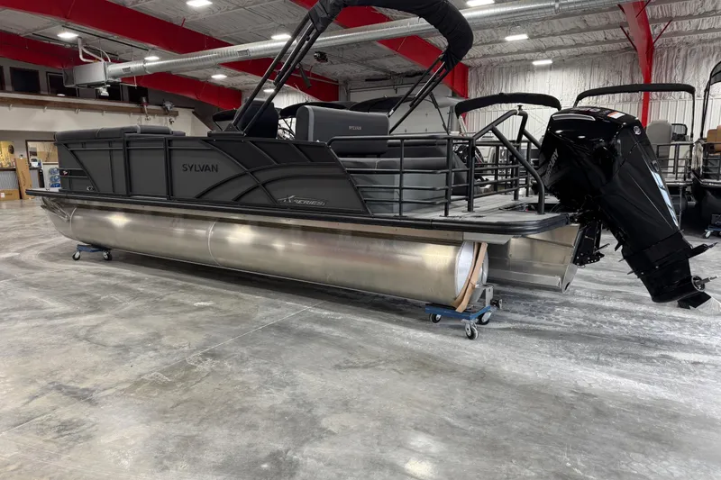 Slide: The Image of 2026 Sylvan X5 pontoon boat in showroom, featuring sleek design and powerful outboard motor. - 4