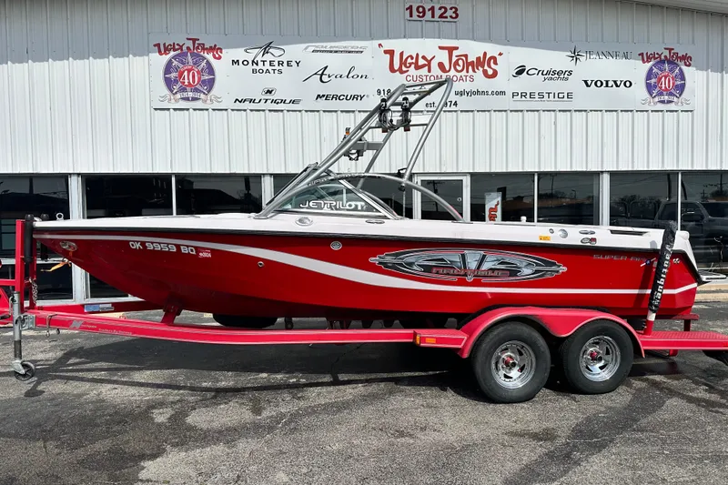 The Image of 2004 Nautique Air Nautique 226 boat in red on trailer outside dealership. - 1