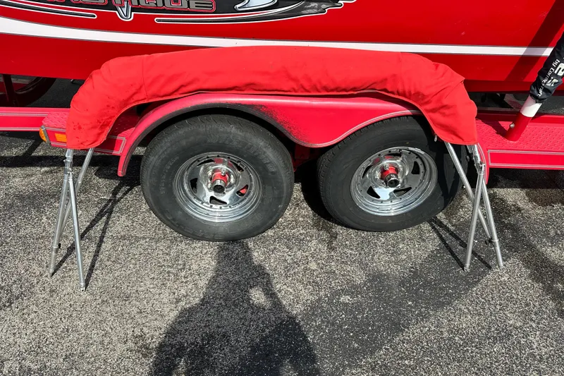 Slide: The Image of Red 2004 Nautique Air Nautique 226 trailer with dual wheels and protective cover. - 11