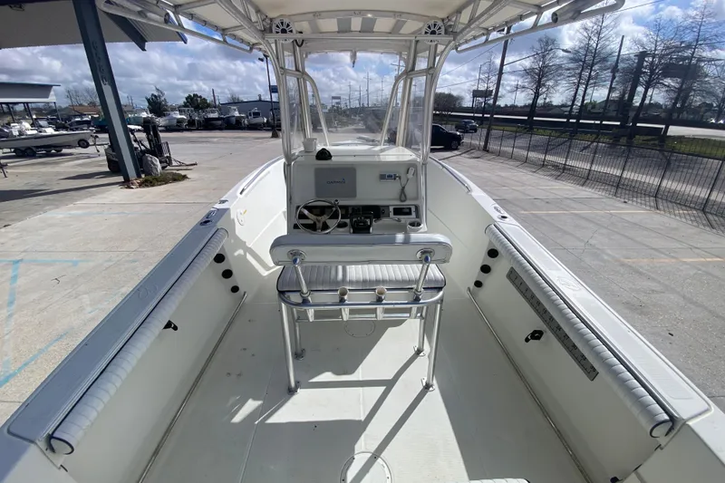 Slide: The Image of 2006 Sailfish 2360 CC boat interior with helm, seating, and equipment under a clear sky. - 13