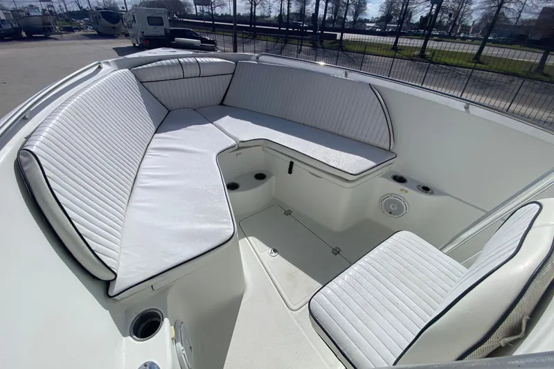 Slide: The Image of 2006 Sailfish 2360 CC boat interior with white cushioned seating and cup holders. - 14