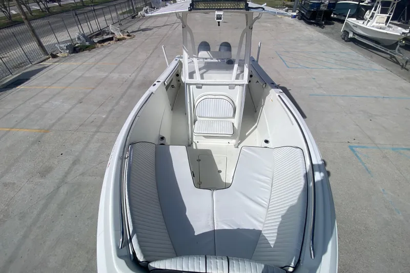 Slide: The Image of 2006 Sailfish 2360 CC boat with spacious seating and sleek design in a marina setting. - 18