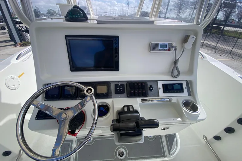 Slide: The Image of Helm of 2006 Sailfish 2360 CC boat with steering wheel and navigation controls. - 19