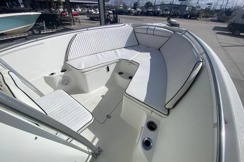 Slide: The Image of 2006 Sailfish 2360 CC boat interior with white cushioned seating and storage compartments. - 21