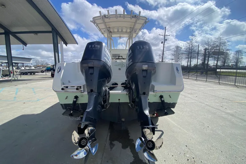 Slide: The Image of 2006 Sailfish 2360 CC boat with dual Yamaha 115 engines, parked outdoors. - 4