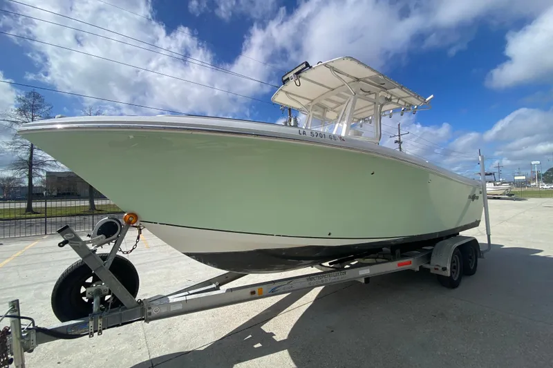 Slide: The Image of 2006 Sailfish 2360 CC boat on trailer under blue sky. - 7