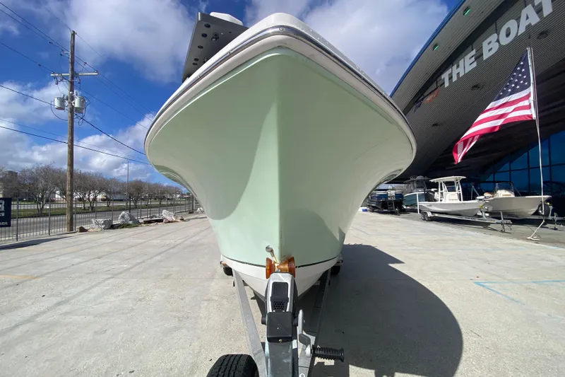 Slide: The Image of 2006 Sailfish 2360 CC boat on trailer, parked outside dealership with American flag. - 8