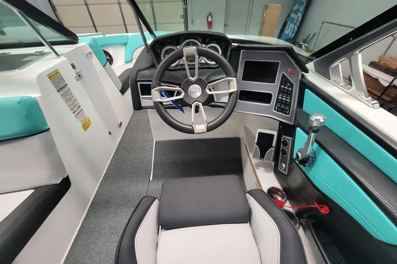 Slide: The Image of 2020 MasterCraft XT23 boat interior with modern dashboard and teal accents. - 13