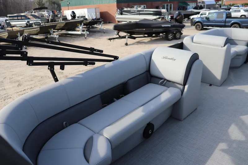 Slide: The Image of 2026 Bentley Pontoons 223 Bolt with luxurious seating, showcased in a boat dealership. - 6
