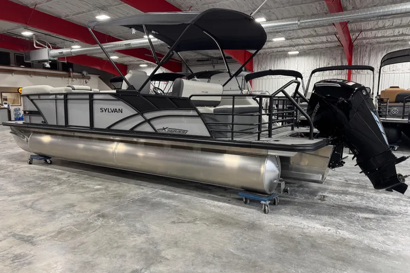 Slide: The Image of 2026 Sylvan X5 pontoon boat in showroom, featuring sleek design and powerful outboard motor. - 4