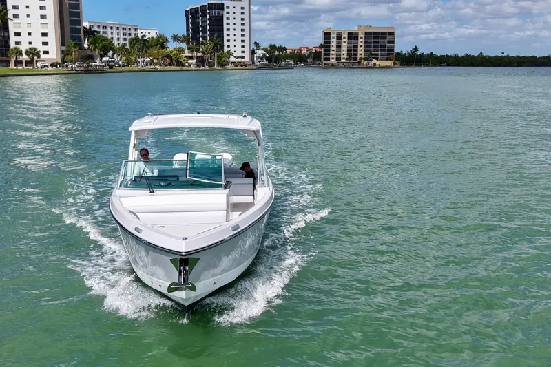 Slide: The Image of 2023 Aviara AV36 OB cruising on a sunny waterfront with modern buildings in the background. - 3