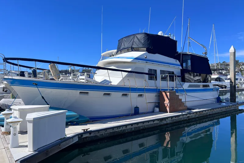 The Image of 1984 Kha Shing Spoiler Cockpit Motor Yacht docked at marina under clear blue sky. - 0