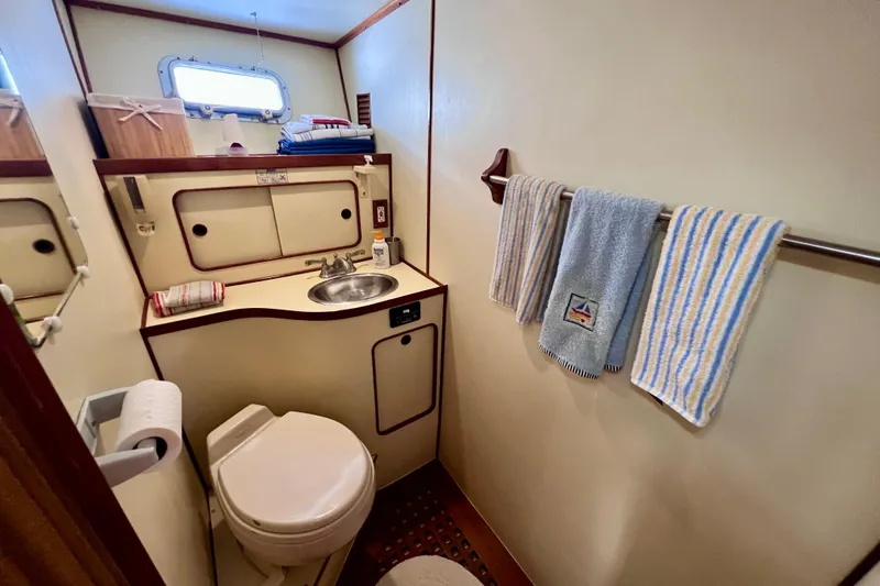 Slide: The Image of 1984 Kha Shing Spoiler yacht bathroom with sink, toilet, and striped towels. - 15