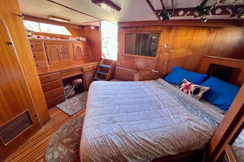 Slide: The Image of 1984 Kha Shing Spoiler Cockpit Motor Yacht interior with wooden furnishings and cozy bed. - 18