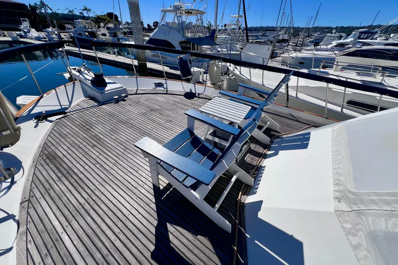 Slide: The Image of 1984 Kha Shing Spoiler Cockpit Motor Yacht deck with chairs, docked at marina. - 21