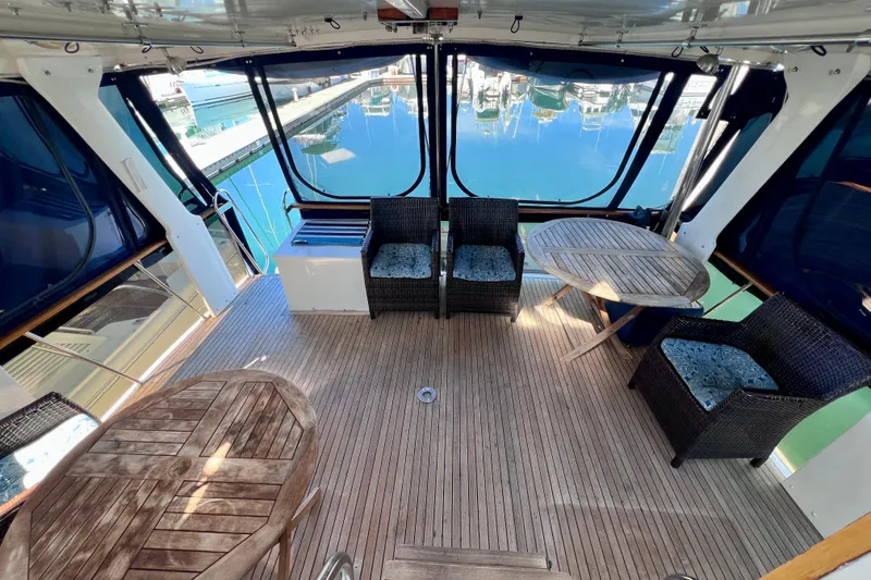 Slide: The Image of 1984 Kha Shing Spoiler Cockpit Motor Yacht interior with wicker chairs and wooden tables. - 3