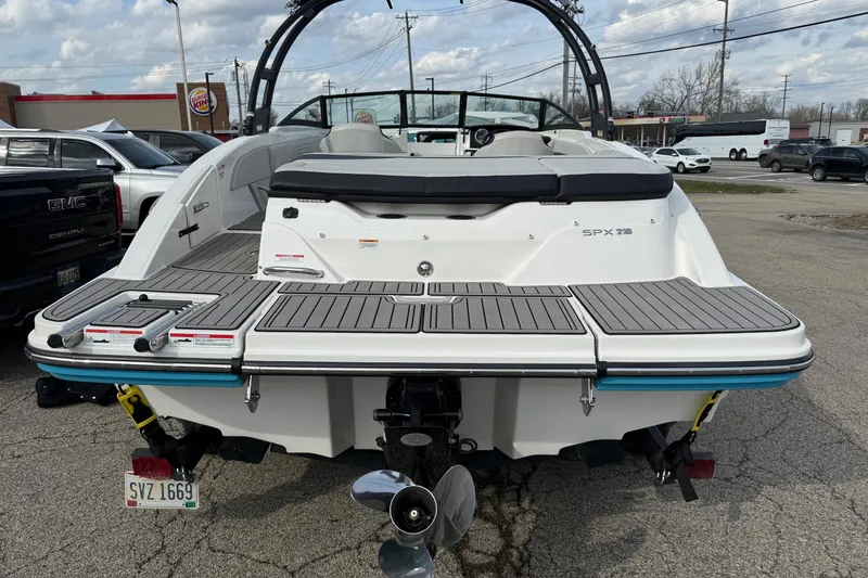 Slide: The Image of 2022 Sea Ray SPX 210 boat, rear view, parked in a lot with visible propeller. - 14