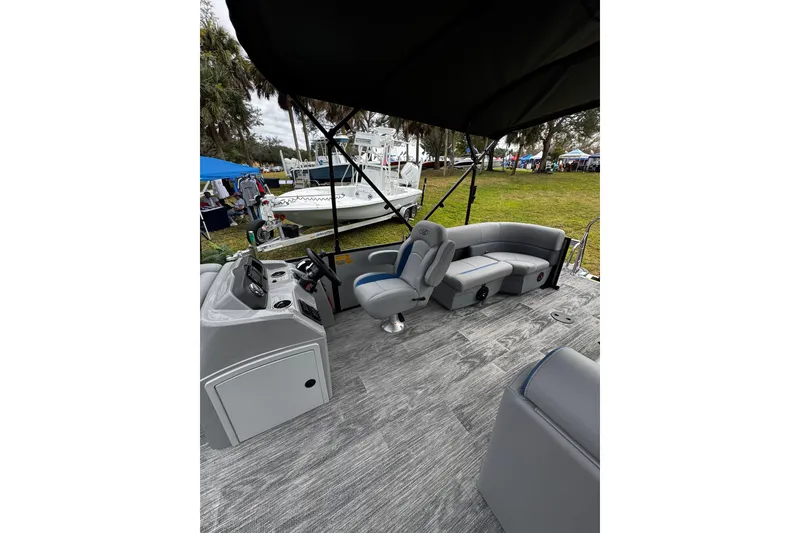 Slide: The Image of 2026 Bentley Pontoons Bolt 223 interior with modern seating and helm, showcased outdoors. - 11
