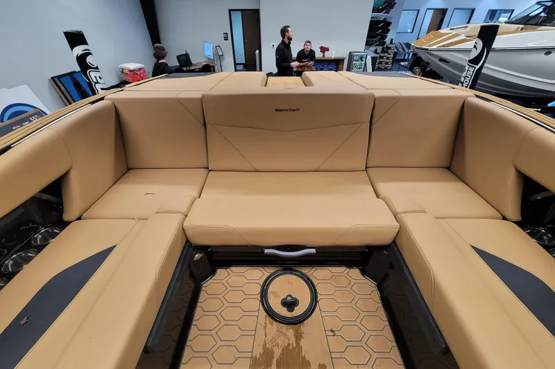 Slide: The Image of 2025 MasterCraft NXT23 boat interior with tan seating and hexagonal floor design. - 11
