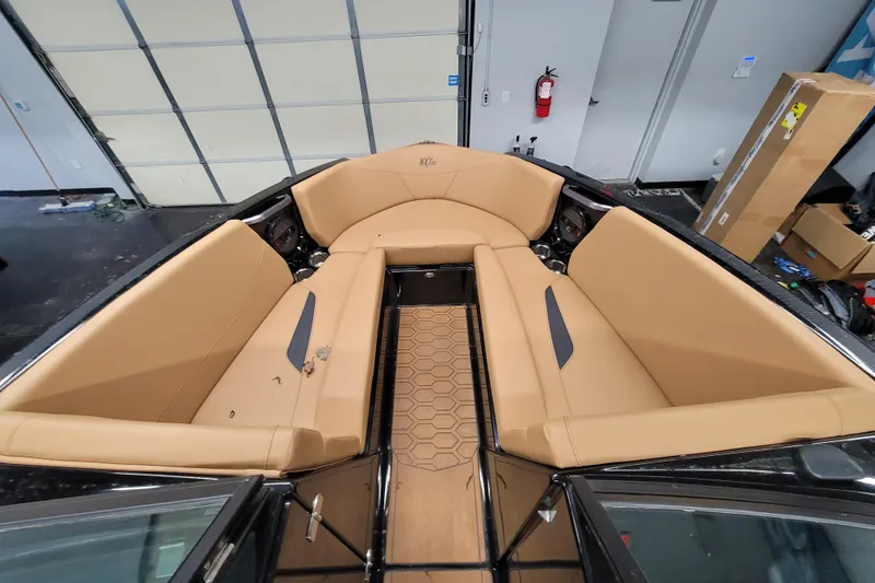 Slide: The Image of 2025 MasterCraft NXT23 boat interior with tan seating and hexagonal floor design. - 16