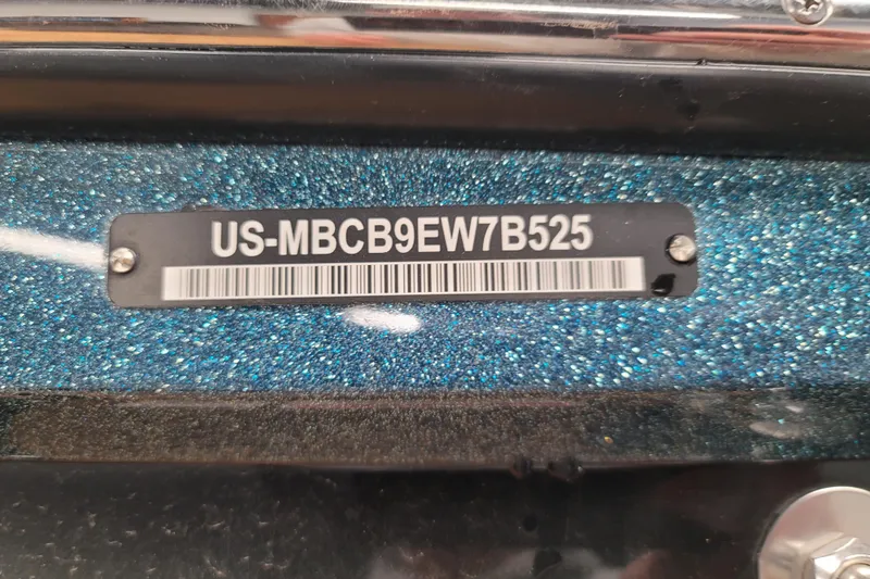Slide: The Image of 2025 MasterCraft NXT23 boat identification plate with serial number on glittery blue surface. - 17