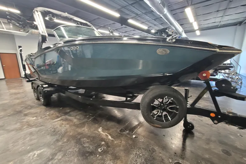 Slide: The Image of 2025 MasterCraft NXT23 boat on trailer in showroom, side view. - 4