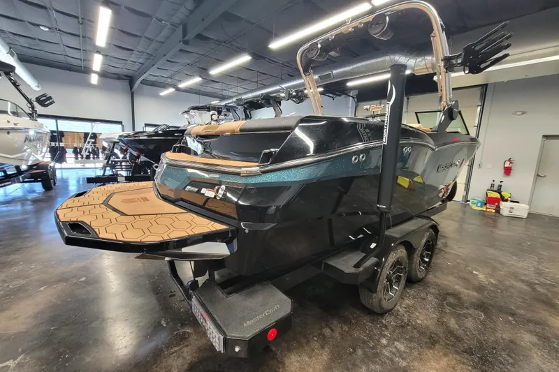 Slide: The Image of 2025 MasterCraft NXT23 boat in showroom, rear view with trailer. - 6