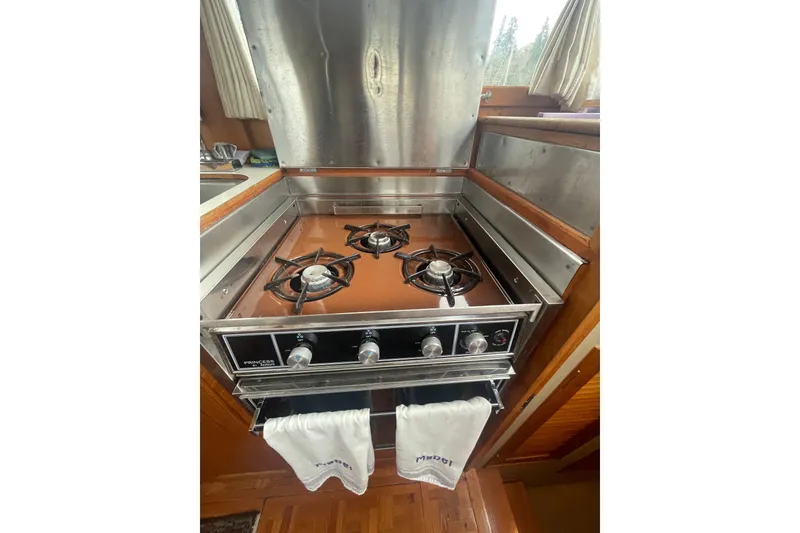 Slide: The Image of 1984 Grand Banks 32 Sedan kitchen with stainless steel stove and wooden cabinetry. - 10