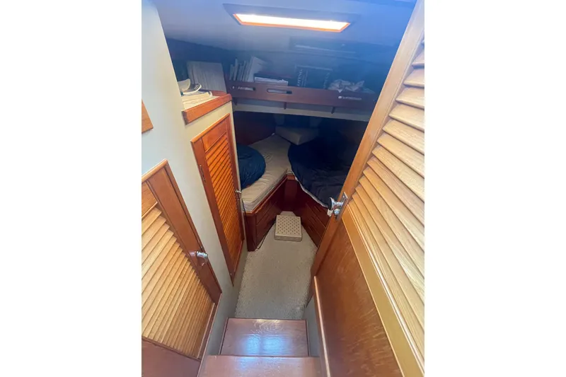 Slide: The Image of 1984 Grand Banks 32 Sedan cabin interior with wooden finishes and cozy sleeping area. - 15