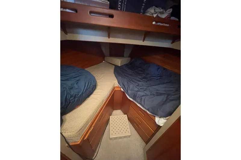 Slide: The Image of 1984 Grand Banks 32 Sedan cabin with twin beds and wooden storage drawers. - 16