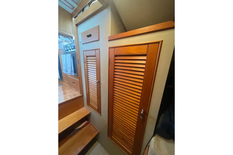 Slide: The Image of 1984 Grand Banks 32 Sedan interior with wooden cabinets and stairs. - 17