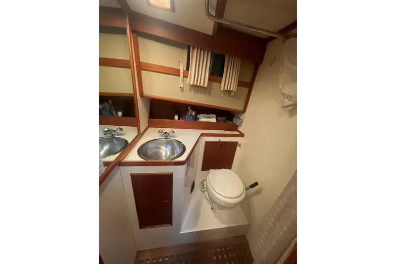 Slide: The Image of 1984 Grand Banks 32 Sedan bathroom with sink, toilet, and wooden accents. - 18