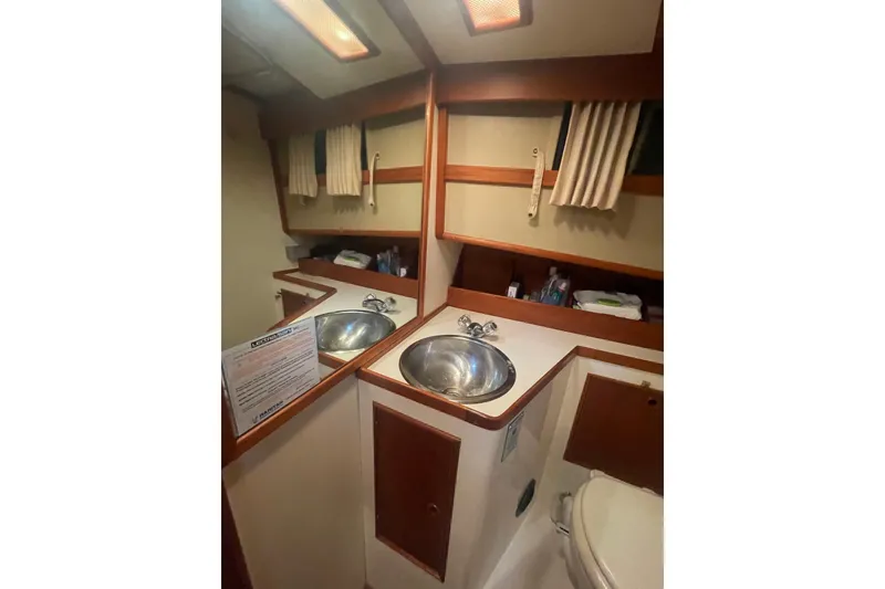 Slide: The Image of 1984 Grand Banks 32 Sedan bathroom with sink, mirror, and storage shelves. - 19