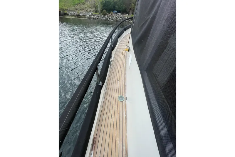 Slide: The Image of 1984 Grand Banks 32 Sedan boat deck with wooden flooring and water view. - 30