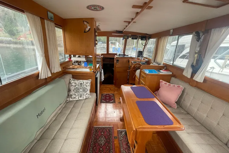 Slide: The Image of 1984 Grand Banks 32 Sedan interior with wooden furnishings and cozy seating. - 6