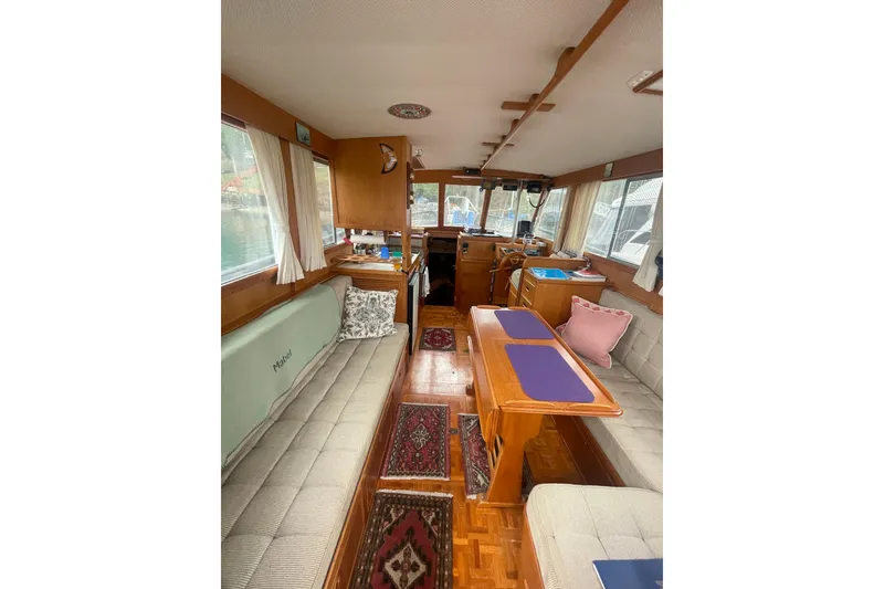 Slide: The Image of Interior of 1984 Grand Banks 32 Sedan, featuring cozy seating and wooden furnishings. - 7