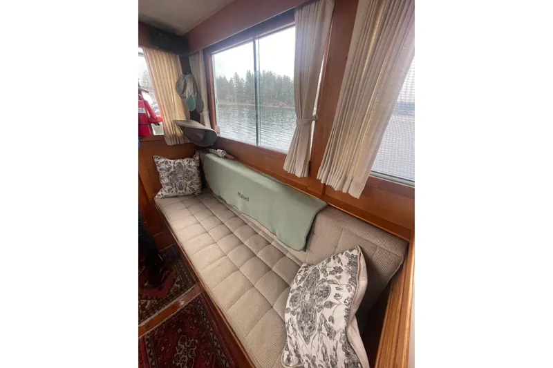 Slide: The Image of Interior of 1984 Grand Banks 32 Sedan with cushioned seating and scenic window view. - 8