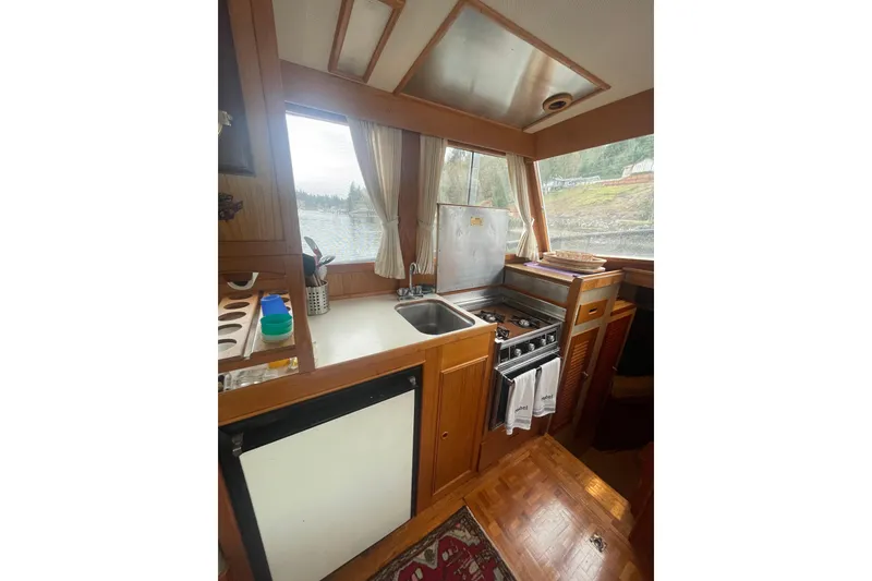 Slide: The Image of 1984 Grand Banks 32 Sedan interior kitchen with stove, sink, and window view. - 9
