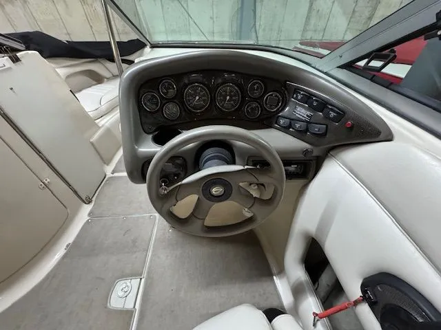 Slide: The Image of Interior view of a 2001 Crownline 230 boat cockpit with steering wheel and gauges. - 8