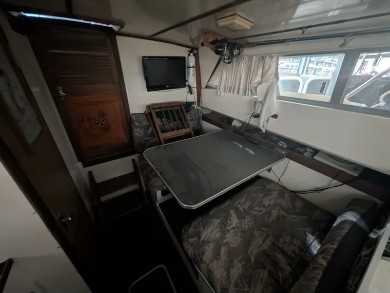 Slide: The Image of Interior of a 1976 Silverton 26' boat with table and TV. - 10
