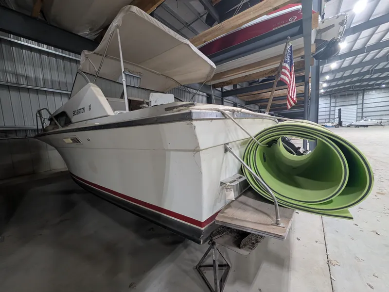 Slide: The Image of 1976 Silverton 26' boat in storage with green mat. - 3