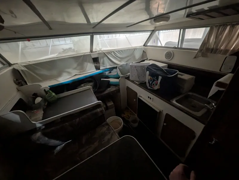 Slide: The Image of Interior of a 1976 Silverton 26' boat, cluttered and dimly lit. - 9