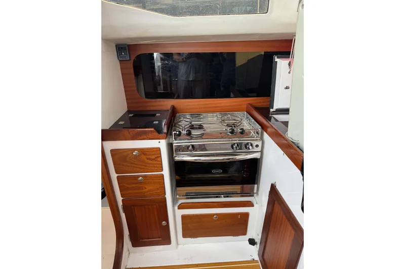 Slide: The Image of 2019 J Boats J/121 yacht interior with stove and wooden cabinetry. - 18