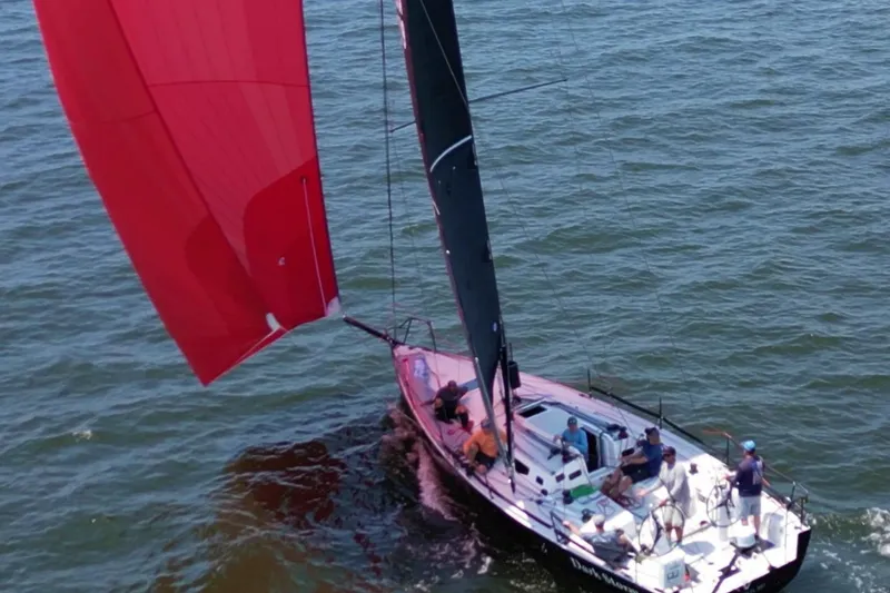Slide: The Image of 2019 J Boats J/121 sailing with red spinnaker on open water. - 3